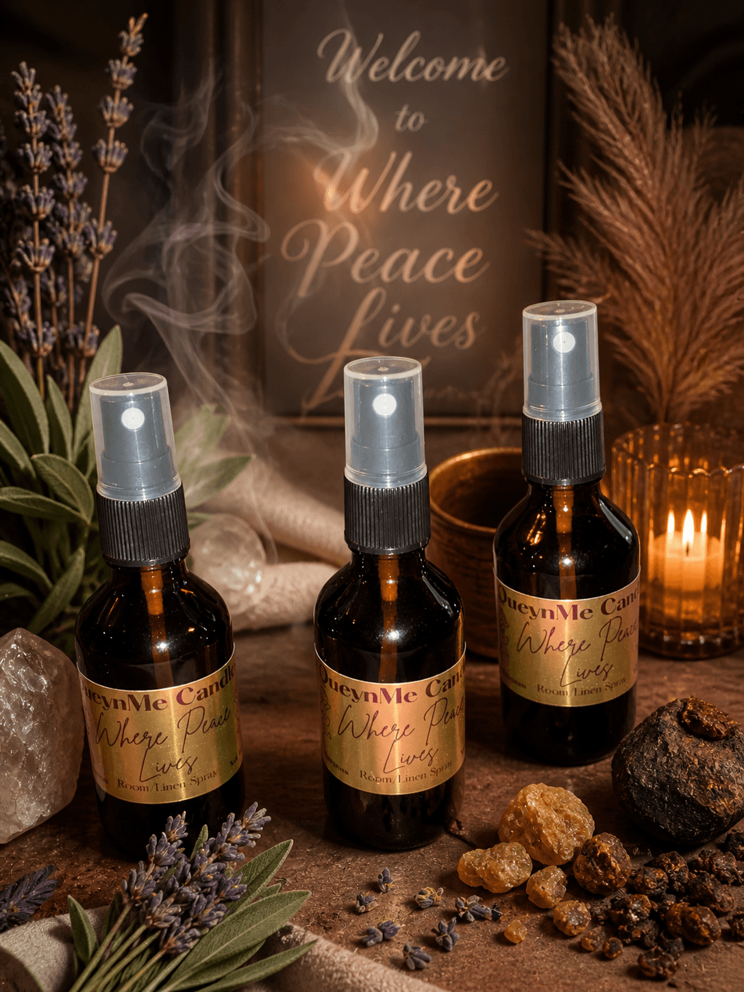 Three spray bottles on a table with plants, rocks, and candles, and a sign reading 'Welcome to Where Peace Lives' in the background.
